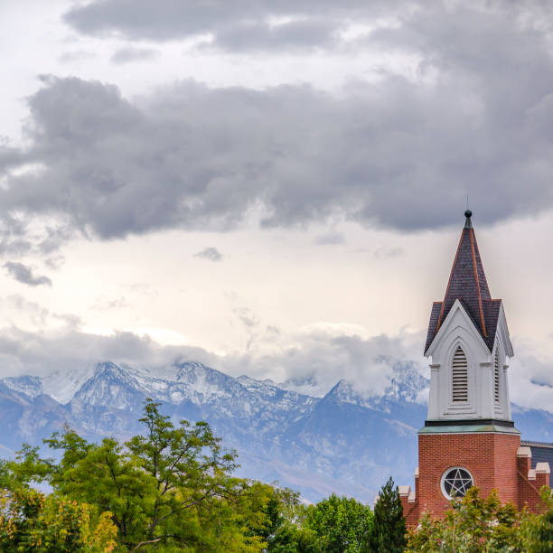 istock Steeple of a church towering over lush trees 1126337714