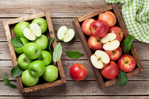 Ripe green and red apples on wooden table. Top view