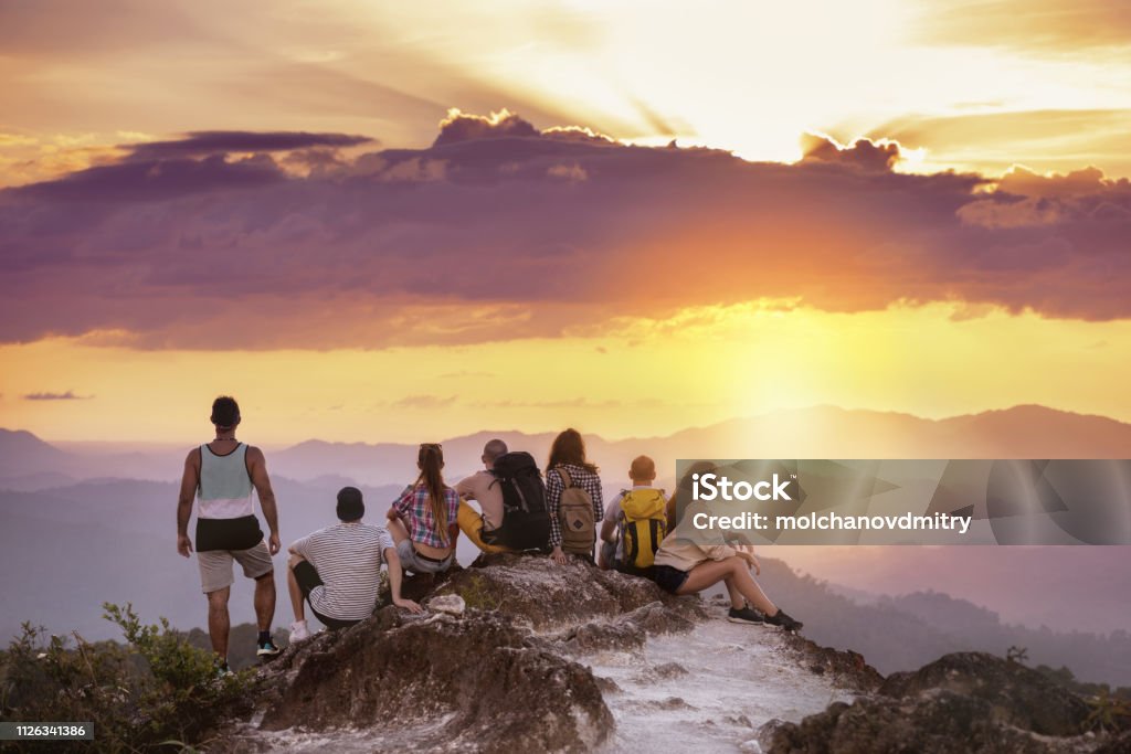 Grupo amigos montaña superior puesta de sol - Foto de stock de Trabajo en equipo libre de derechos