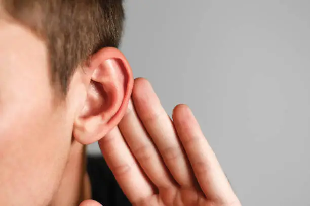 Photo of Man with hearing problem on grey background. Close up