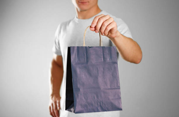 istock Man holding a blue gift bag. Close up. Isolated background 1126343910