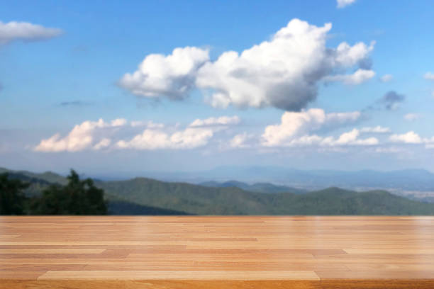 istock Empty wooden and table on abstract nature view with cloud, blue sky, leaf and mountain background 1126359600