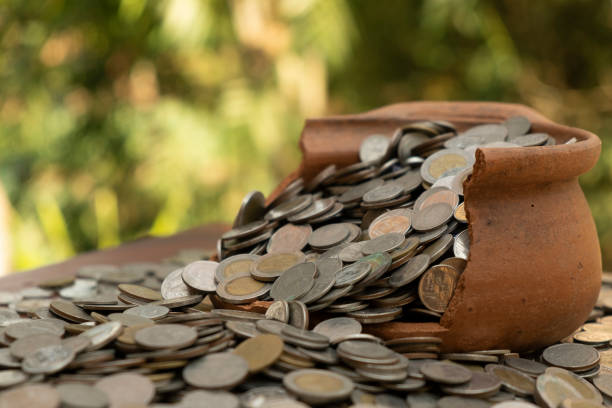 istock Coins in broken jar from on pile lots coin with blurred background, Money stack for business planning investment and saving concept 1126365467
