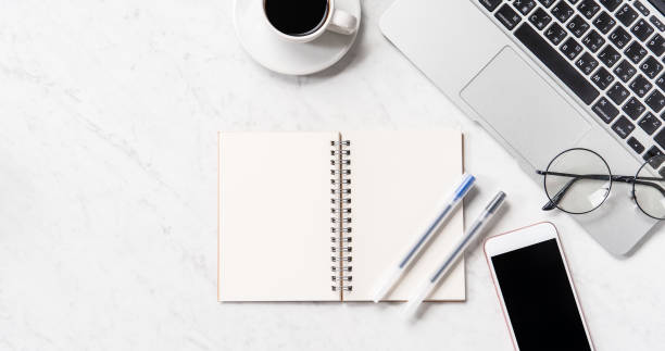 istock Stylized marble office working desk with smartphone, laptop, glasses and coffee, workspace design, mock up, topview, flatlay, copyspace, closeup 1126370021