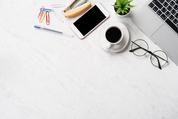 istock Stylized marble office working desk with smartphone, laptop, glasses and coffee, workspace design, mock up, topview, flatlay, copyspace, closeup 1126370024