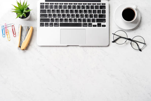 istock Stylized marble office working desk with smartphone, laptop, glasses and coffee, workspace design, mock up, topview, flatlay, copyspace, closeup 1126370093
