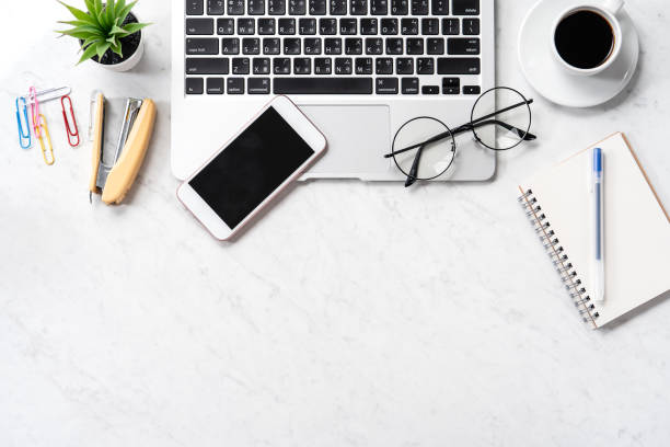 istock Stylized marble office working desk with smartphone, laptop, glasses and coffee, workspace design, mock up, topview, flatlay, copyspace, closeup 1126370129