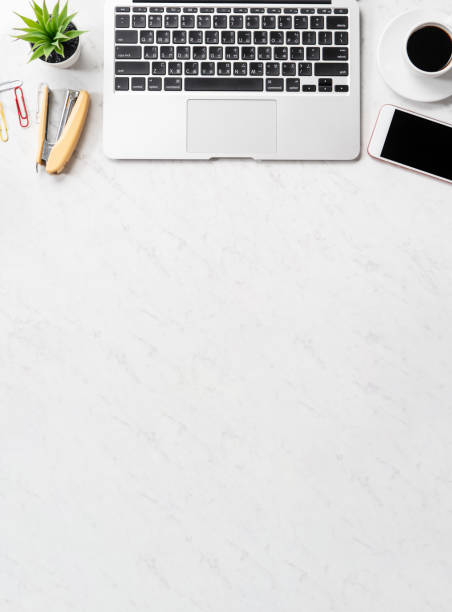 istock Stylized marble office working desk with smartphone, laptop, glasses and coffee, workspace design, mock up, topview, flatlay, copyspace, closeup 1126370157