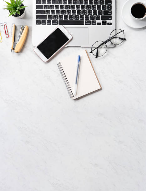 istock Stylized marble office working desk with smartphone, laptop, glasses and coffee, workspace design, mock up, topview, flatlay, copyspace, closeup 1126370238