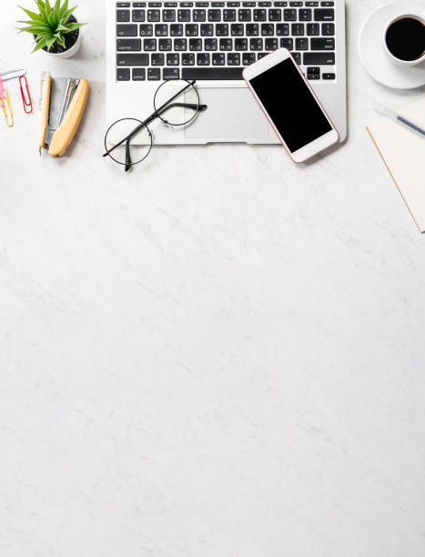 istock Stylized marble office working desk with smartphone, laptop, glasses and coffee, workspace design, mock up, topview, flatlay, copyspace, closeup 1126370272