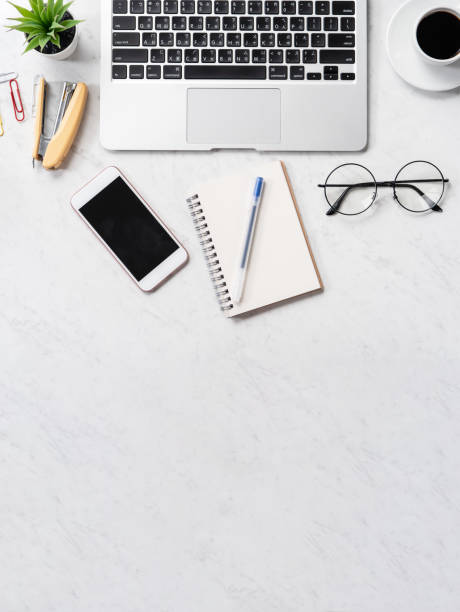 istock Stylized marble office working desk with smartphone, laptop, glasses and coffee, workspace design, mock up, topview, flatlay, copyspace, closeup 1126370294