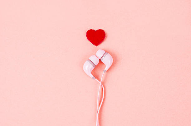 słuchawki z czerwonym sercem na różowym tle. - valentines day hearts audio zdjęcia i obrazy z banku zdjęć