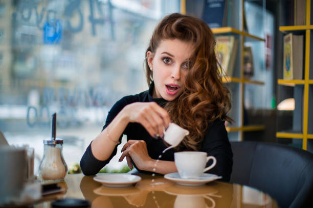 istock Woman being surprised at cup spilling. Looks at camera. 1126372737