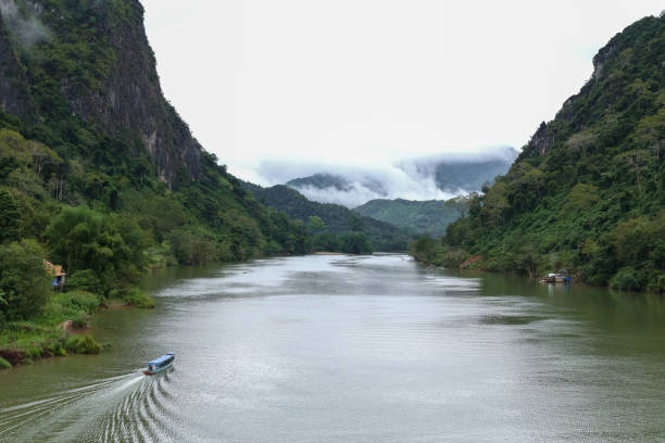 istock Nam Ou river view with small long boat sailing. A valley surrounded by steep limestone cliffs covered with jungle. Image taken in Nong Khiaw - a village in the Luang Prabang Province of northern Laos. 1126375238