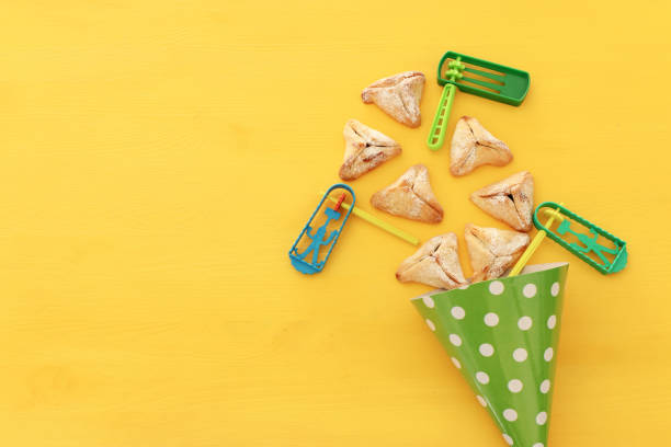 istock Purim celebration concept (jewish carnival holiday) over wooden yellow background. 1126377144