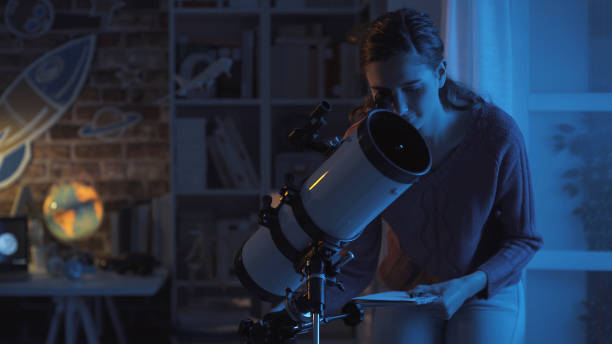 Young smart woman studying astronomy and watching the stars using a telescope, science and discovery concept