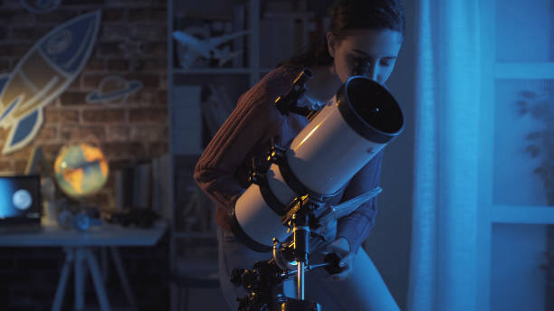 istock Young smart woman studying astronomy and watching the stars using a telescope, science and discovery concept 1126377539