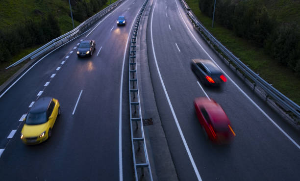 istock car lights at night on the road going in the city 1126377610