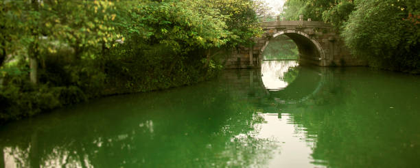 istock There is a stone bridge on the green lake water 1126379423