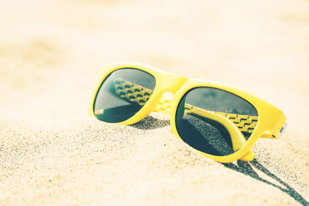 istock Bright fashionable sunglasses on the sand 1126380445