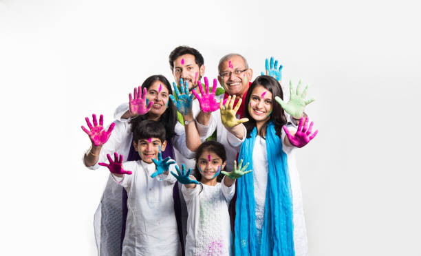 family celebrating holi happy Indian/asian family celebrating Holi festival with colours. Multi generation people standing isolated over white background. selective focus beautiful traditional indian girl stock pictures, royalty-free photos & images