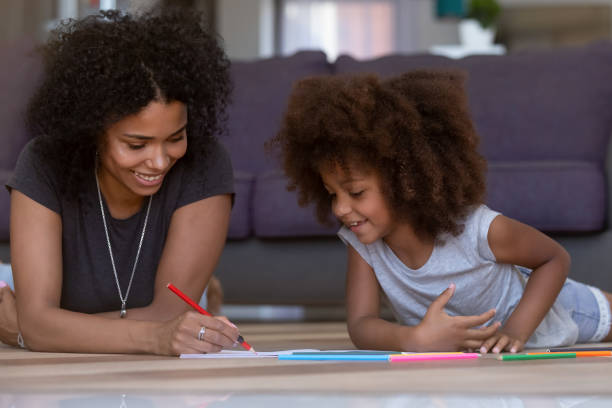 istock Happy mixed-race mom and kid daughter draw with colored pencils 1126384484