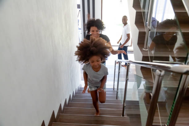 feliz niño africano con padres corriendo arriba en casa nueva - moving house physical activity real estate couple fotografías e imágenes de stock