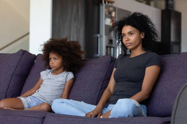 istock Sulky african child and mother sitting on sofa not talking 1126384520