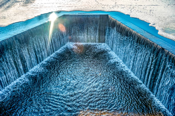 rapid stream of water falling down from a concrete dam