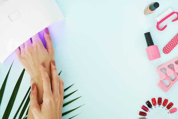 istock beautiful female manicured hands and manicure tools on blue table 1126386657