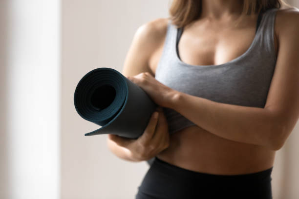 istock Toned woman holding mat ready for yoga workout 1126387381