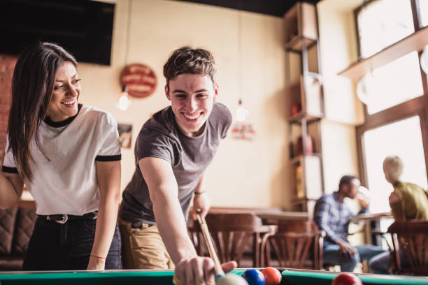 istock Young man teaching his girlfriend to play pool 1126387601