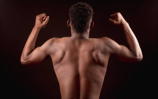 istock back view image of Afro american strong male bending elbows the biceps 1126387726