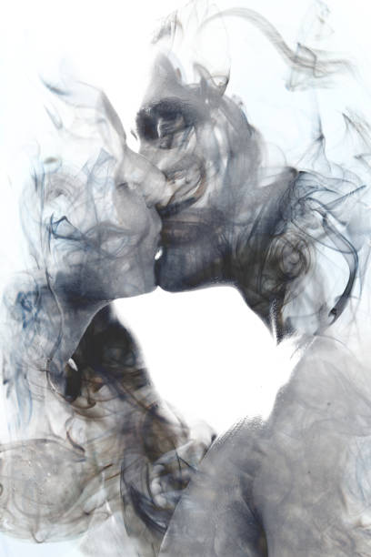Double exposure of two blissful people close up embracing and becoming one with the smoky texture, black and white stock photo