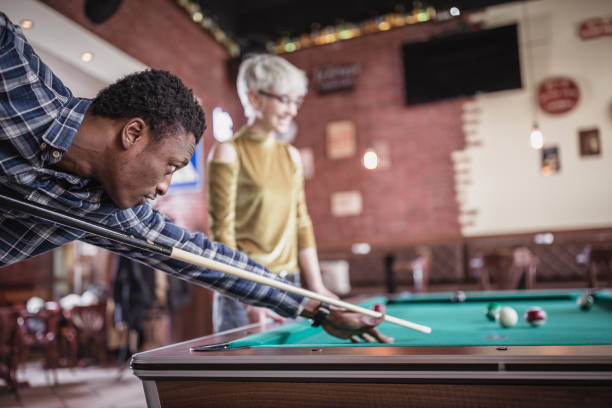 istock Young man teaching his girlfriend to play pool 1126387906