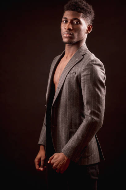 istock Handsome muscular Afro young man in classical jacket on naked torso 1126388539
