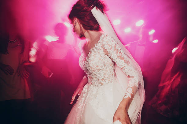 istock stylish happy bride dancing at wedding reception. gorgeous wedding couple having fun and partying in restaurant in light show. newlywed emotional moment. space for text 1126395474