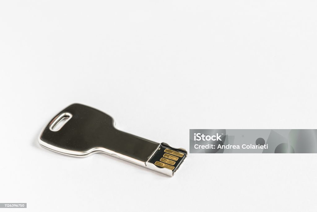 A usb key shaped like a metal key on a white background Byte Stock Photo