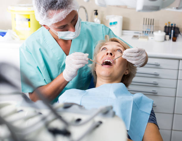 istock Male dentist with female patient during checkup 1126397295