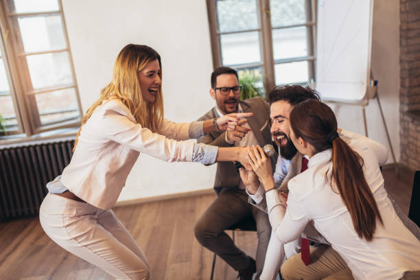 istock Business people singing karaoke in modern office 1126399150