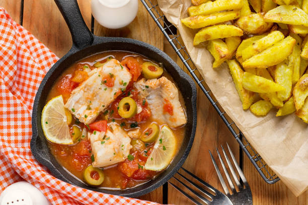 Cod fish cooked in tomato sauce with olives, lemon and tomato