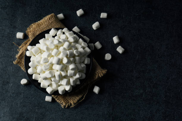 istock White Fluffy white marshmallows in black bowl isolated on black background. 1126399468