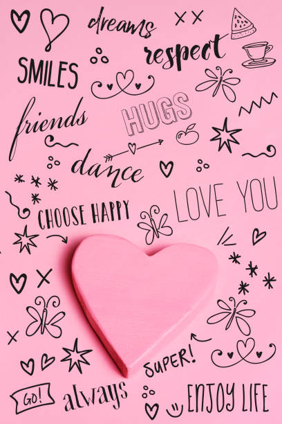 closeup of a pink heart and some different wishes and drawings on a pink background