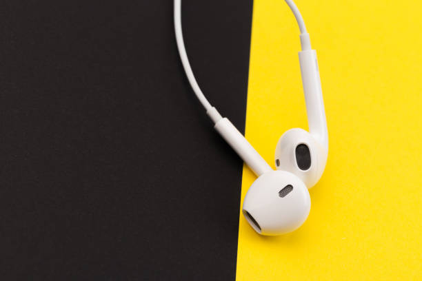 istock white earphones on black  and yellow background 1126399816