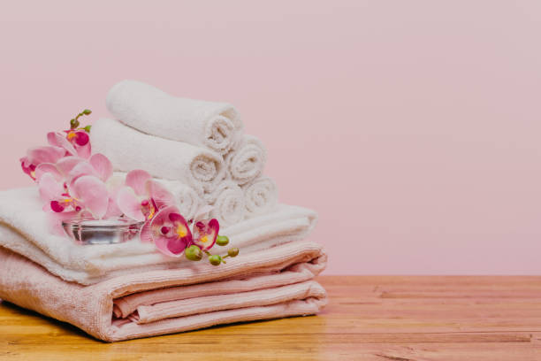 istock Stack of clean soft towels with orchid flower on pink background - Image 1126399913
