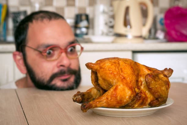 istock Man Looking At Roasted Chicken In Kitchen At Home 1126400005