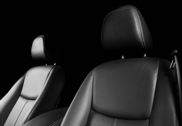 istock Black leather interior of a car. Perforated Leather comfortable seats with stitching isolated on black background. Car interior details. Car detailing. Car inside 1126400078