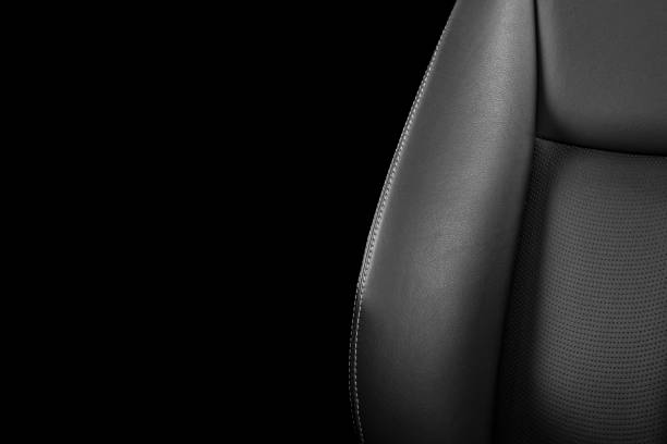 istock Black leather interior of a car. Perforated Leather comfortable seats with stitching isolated on black background. Car interior details. Car detailing. Car inside 1126400196