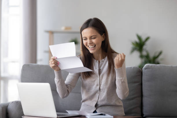 Excited girl holding mail letter feels happy reading great news Excited girl student customer holding mail paper letter bank statement feels happy reading great news about admission scholarship, get accepted hired new job employment opportunity, good test results college acceptance letter stock pictures, royalty-free photos & images