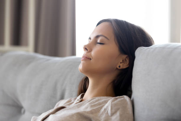 istock Serene calm woman relaxing leaning on comfortable couch having nap 1126400349